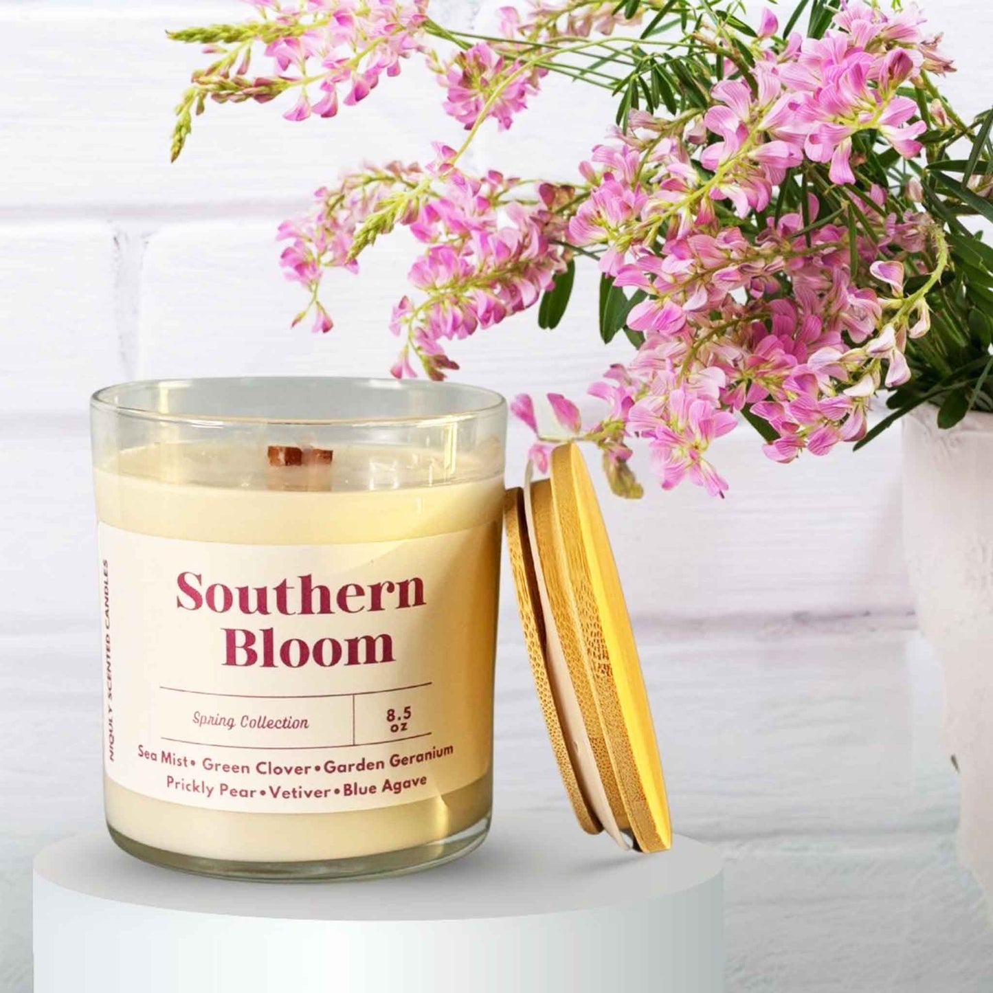 A lit Southern Bloom candle in a charming southern-style setting
