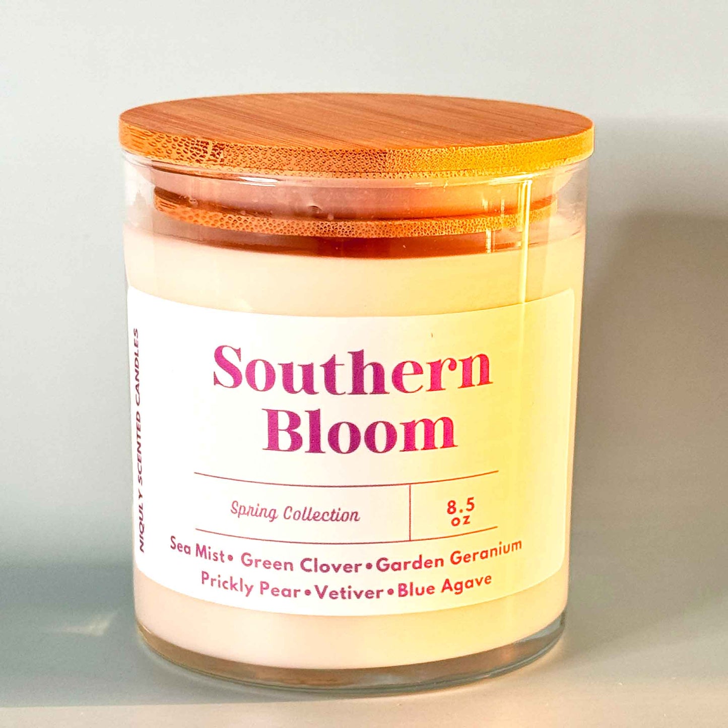 Southern Bloom scented candle in a glass jar, gently flickering.