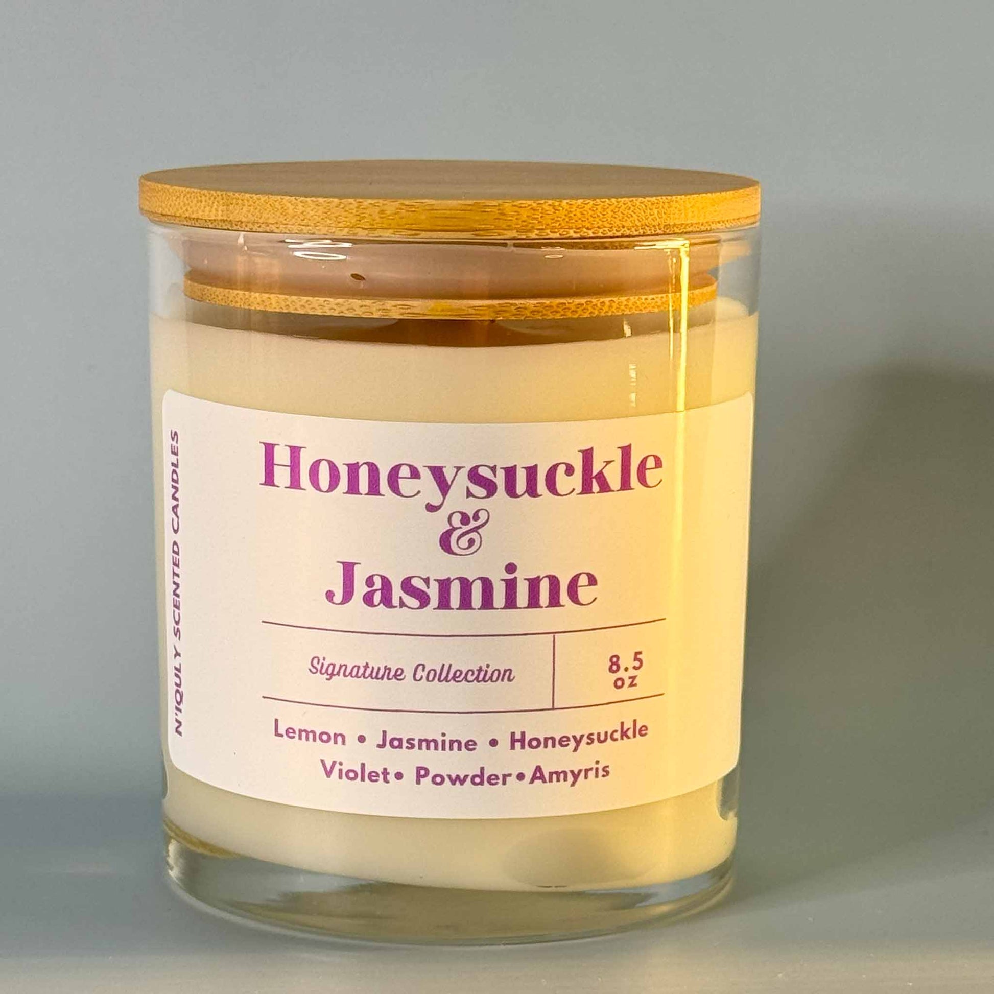 Elegant Honeysuckle & Jasmine scented candle in a round glass jar.

